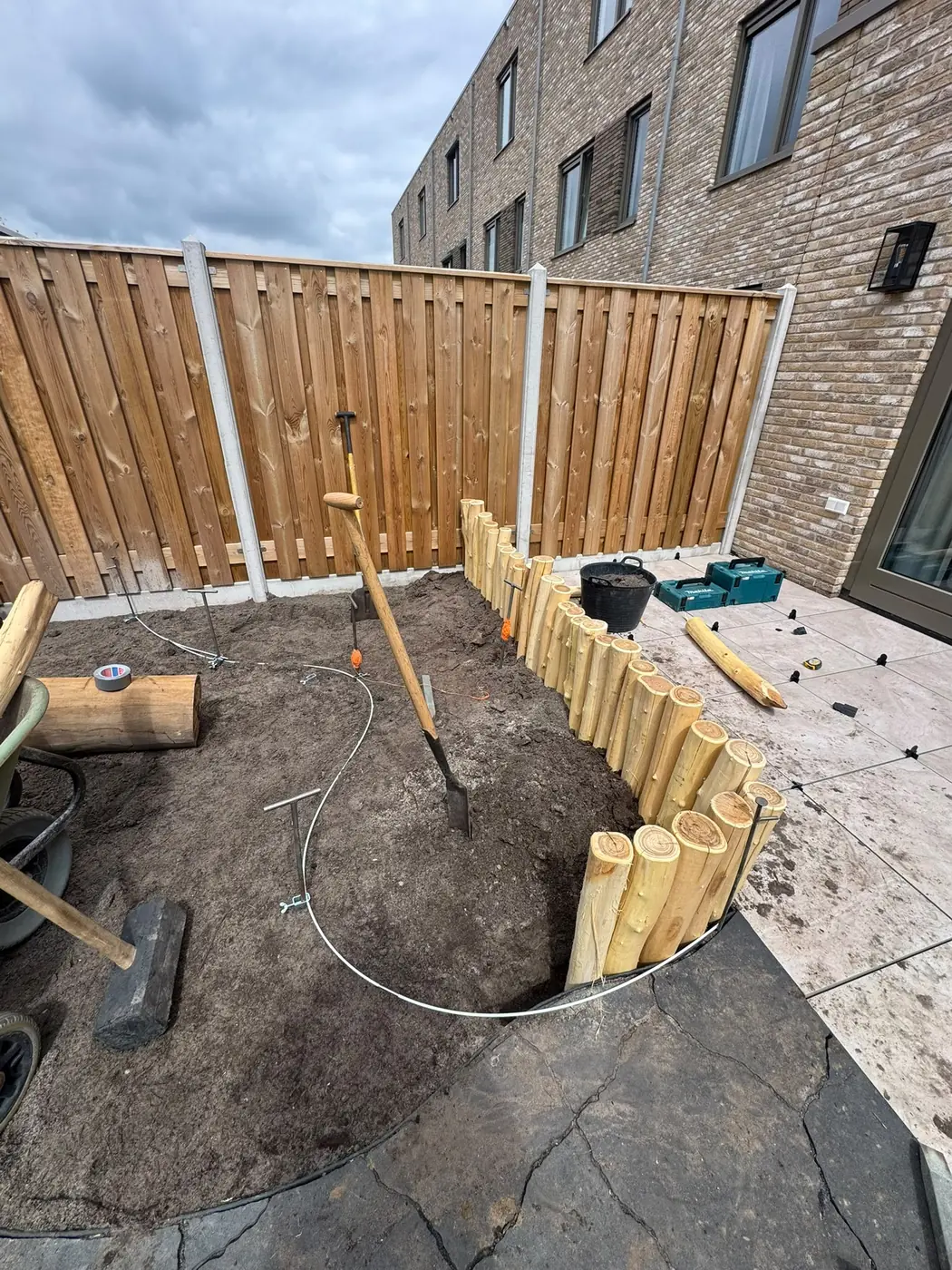 Rondhouten palenrand plaatsen in een achtertuin, door Tuinrobuust