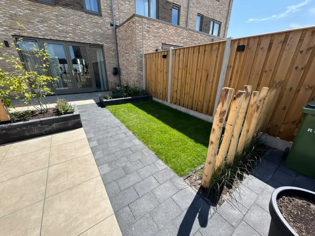 Nieuw aangelegde achtertuin met gazon en houten schutting, door Tuinrobuust